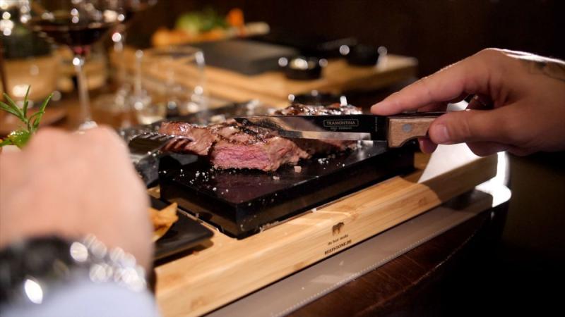 Beefstone (R) in use: grilling on the hot lava stone directly at the table ( (C) )