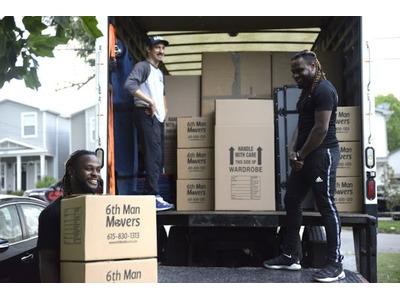 The team from 6th Man Movers is all smiles while efficiently loading boxes into their moving truck, showcasing their reliable and friendly service.