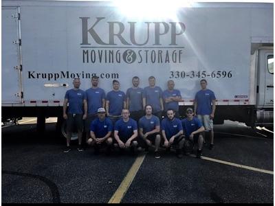 The Krupp Moving & Storage team poses in front of their branded truck, representing their commitment to professional moving services.