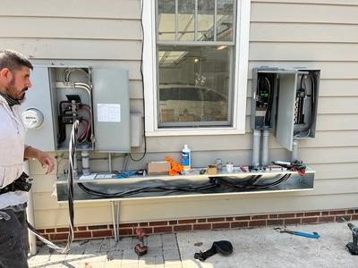 This press image illustrates the comprehensive electrical repair greensboro capabilities provided by Triad Electric Solutions - Electrician Greensboro NC. The visual demonstrates a technician managing a complex residential exterior electrical service upgr