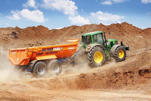 John Deere tractor with trailer skip are the ideal team in the agricultural everyday life.