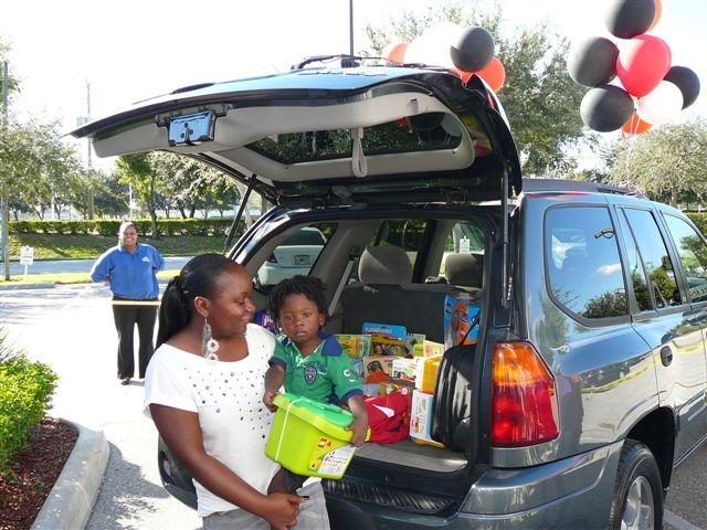 A mother and son receive a recycled ride and other goodies donated by Allstate and Sterling Autobody Centers.