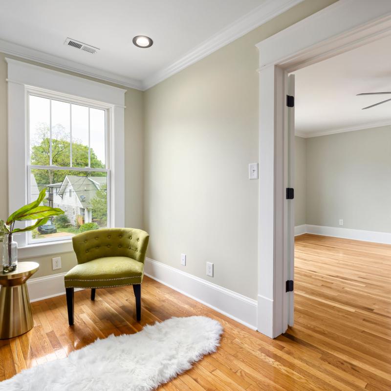 Inside design essentials - natural light, warm wood floors, and a statement accent chair create an inviting home interior