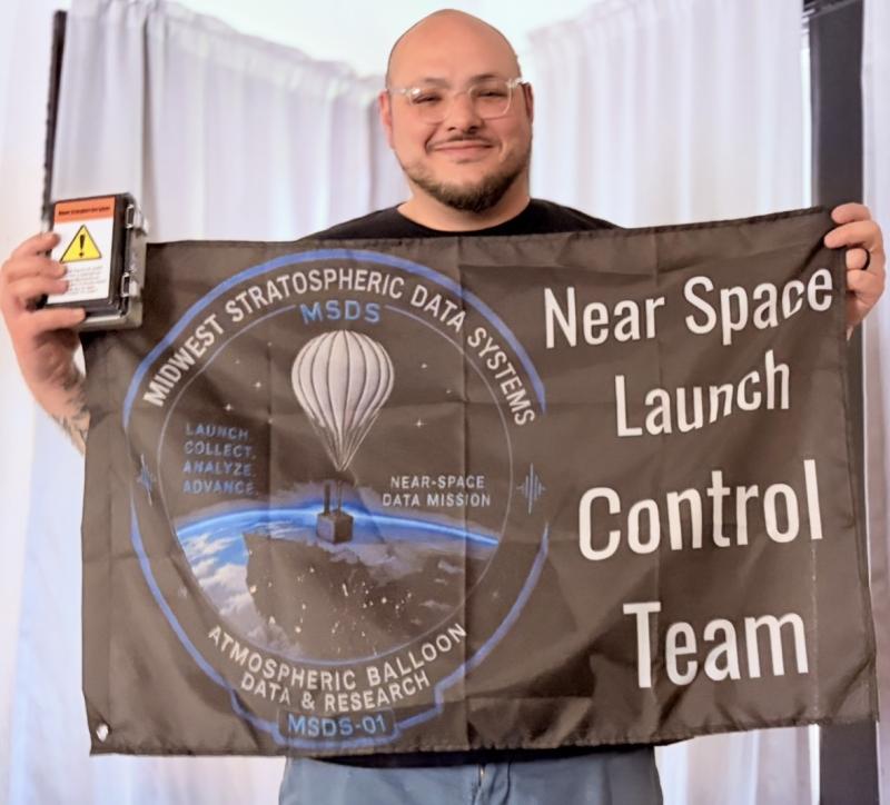 Jeremy David Higgs, CEO of Midwest Stratospheric Data Systems, proudly displays the company's Near Space Launch Control Team flag