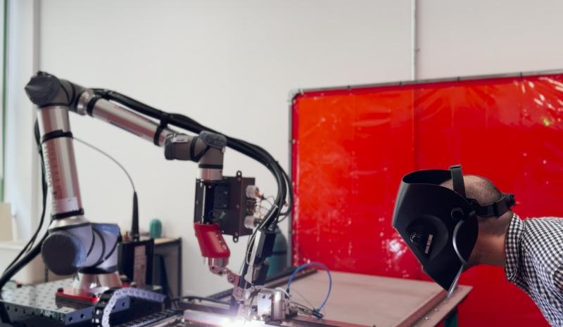 An operator inspects the TIG welding process of the Smart Welding Robotic Workcell.