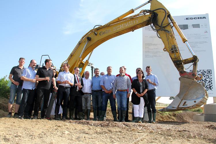 Guests and staff celebrate the ground-breaking. Instead of a spade, the big excavator shovel starts its work immediately