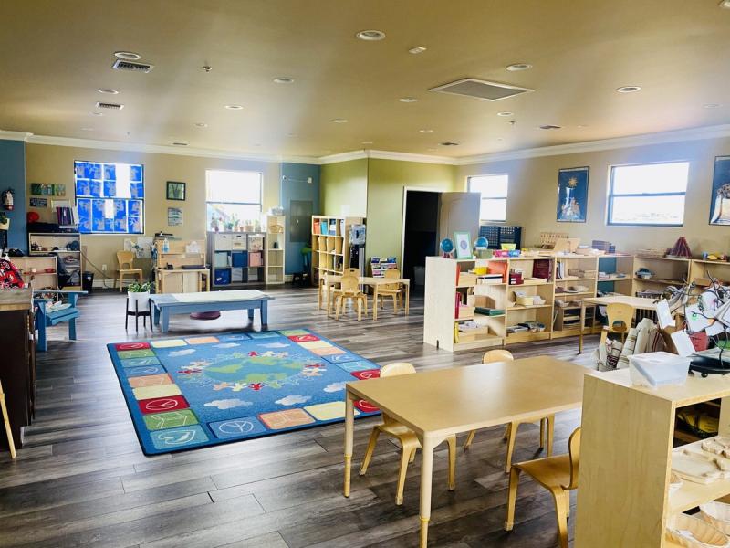 Small Miracles Education classroom with learning centers, tables and a reading rug in Tucson, Arizona