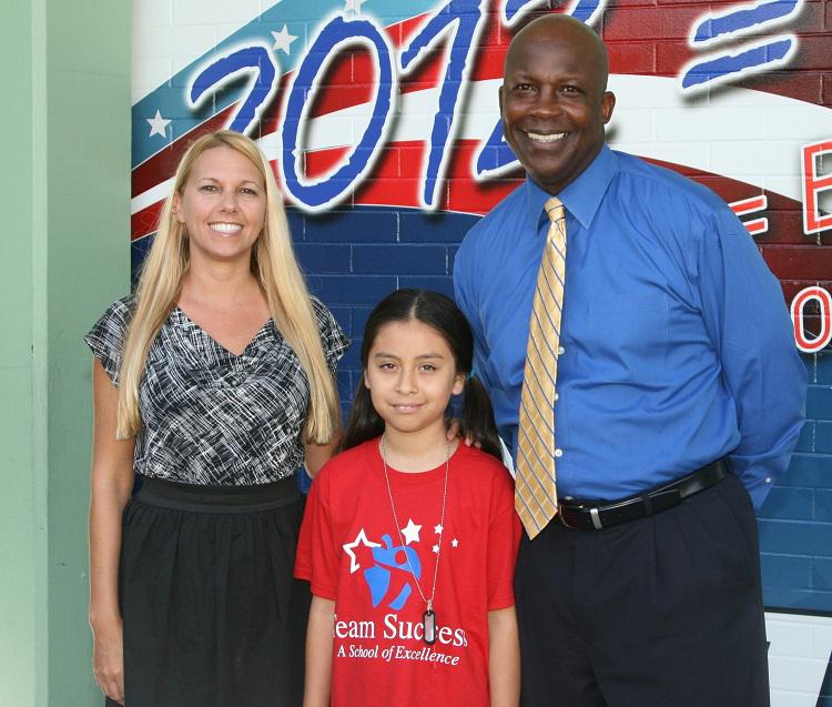 School Director Aimiee Fleming and Principal Fred Spence congratulate student Fritzi Santiago
