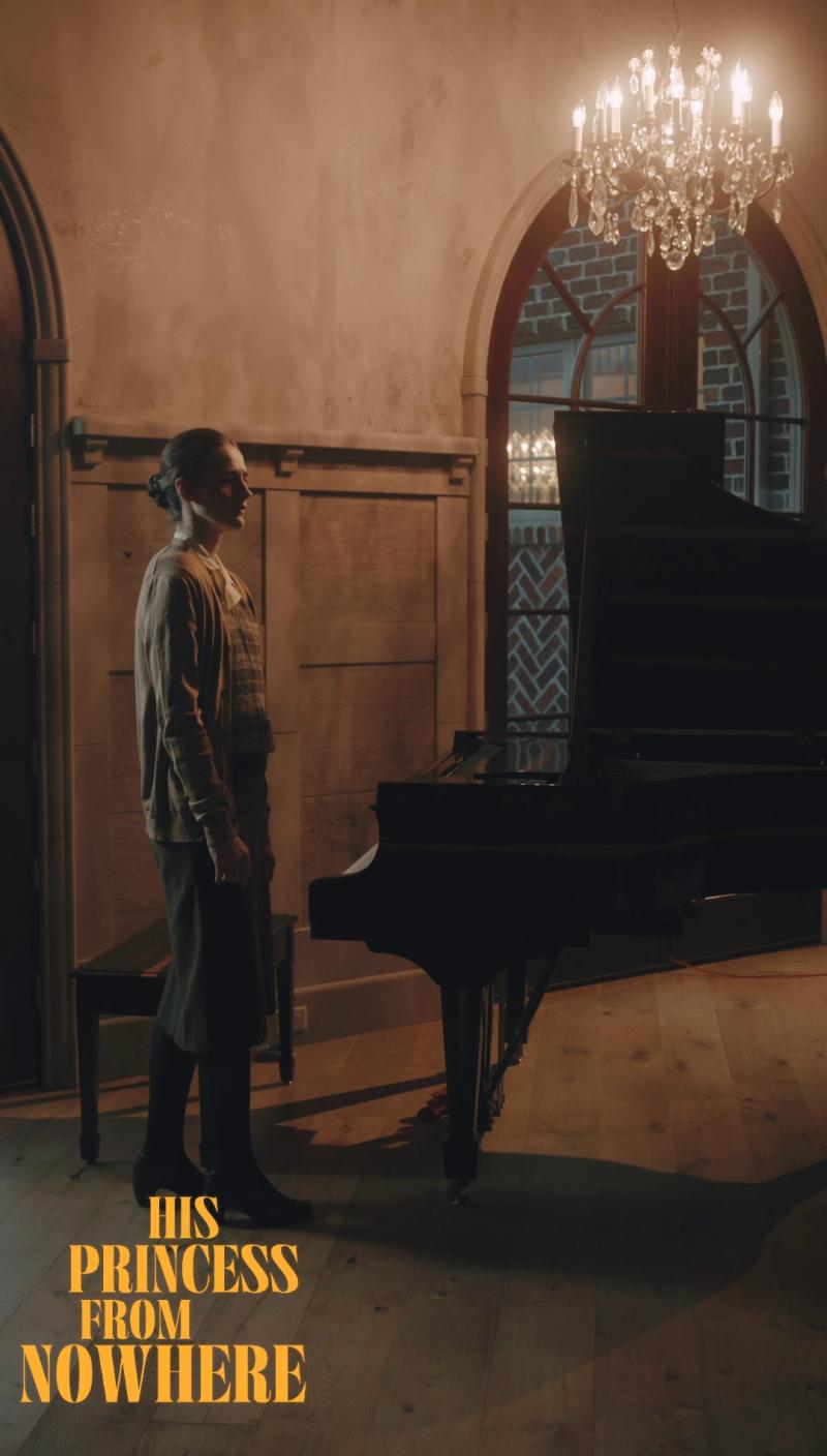 Lucy Lay stands in the piano room of the Rich Manor in His Princess from Nowhere.