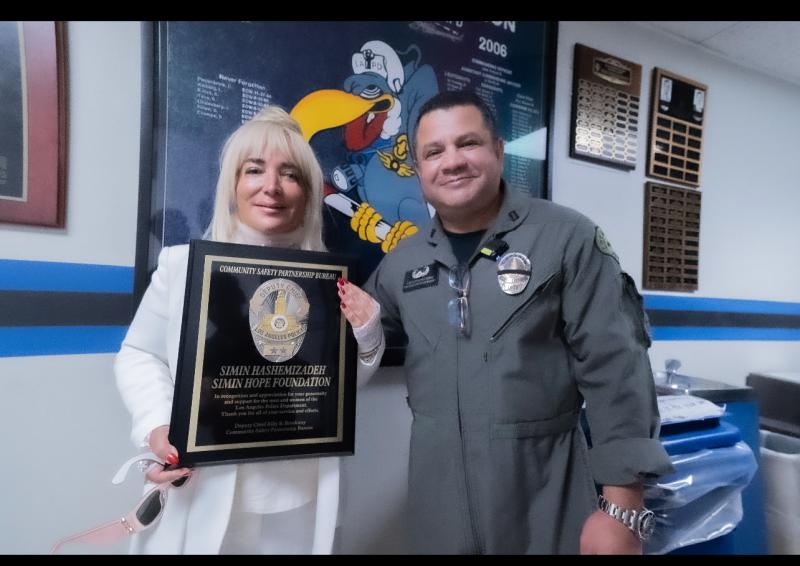 Simin Hashemizadeh receives award presented Captain James Lopez at the LAPD Heliport