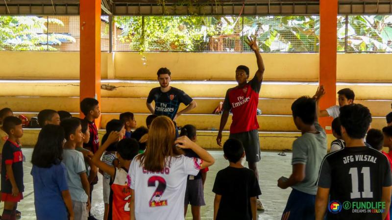 Coach Oscar Wilson and Alangel Joseph doing drills during the Arsenal in the Community Football Clinic.