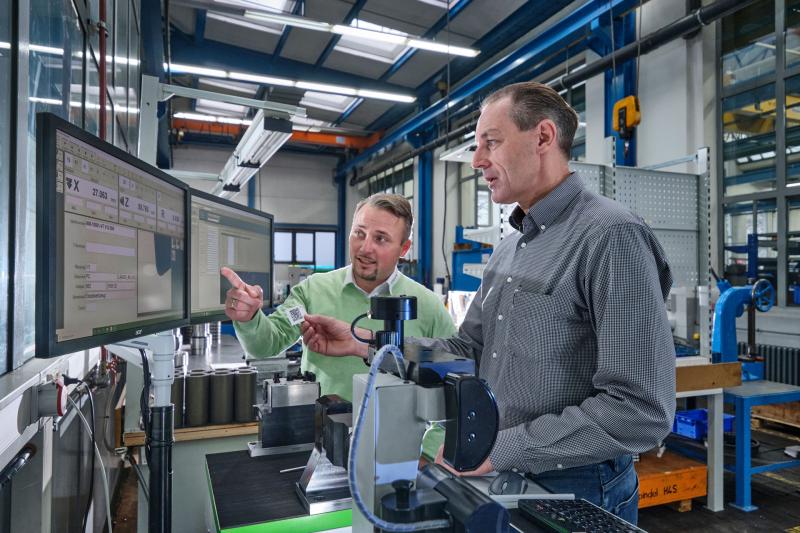 (from left:) Bastian Birkenfeld of KELCH demonstrates label printing on the KENOVA set line H3 to Schütte's Frank Erbstößer.