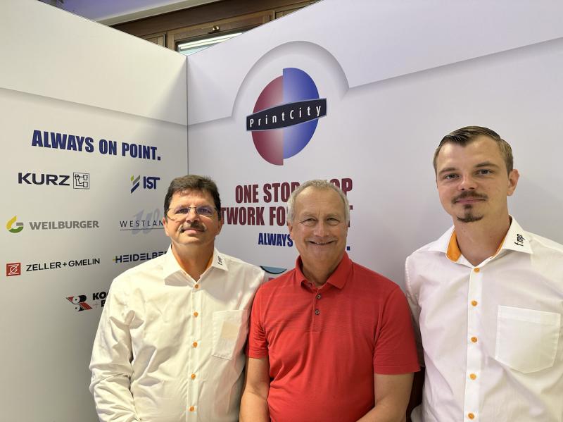 Rainer Kuhn (middle) passes the baton for "PrintCity" to Rüdiger (left) and Marcel Maaß from "f:mp.".