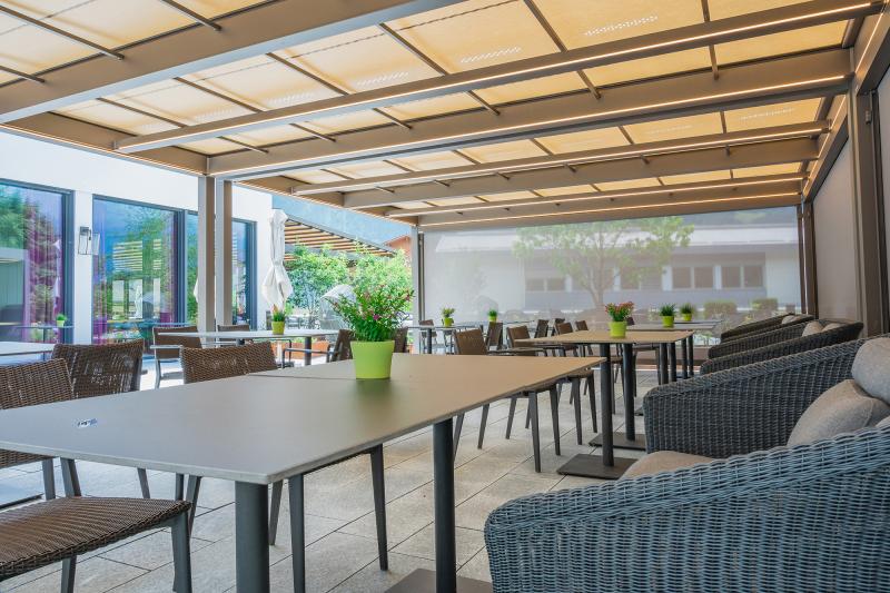 The markilux awning systems are intended to protect the restaurant area from both rain and sun during the summer season.