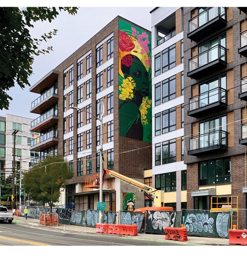 Mural of Ade Cônnére and Riz Rollins seen form Yesler Street in Seattle