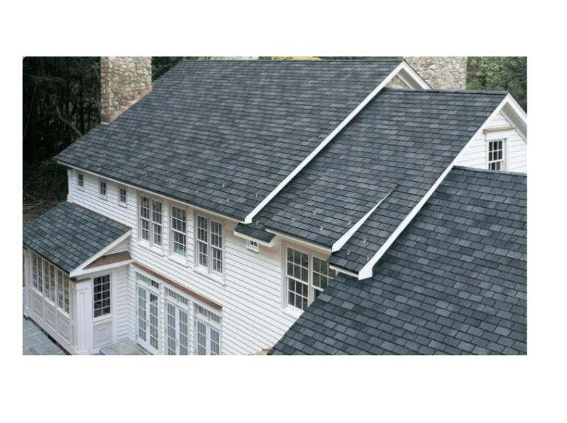 A newly installed dark gray shingle roof on a large, modern home highlights quality roofing craftsmanship and durability.