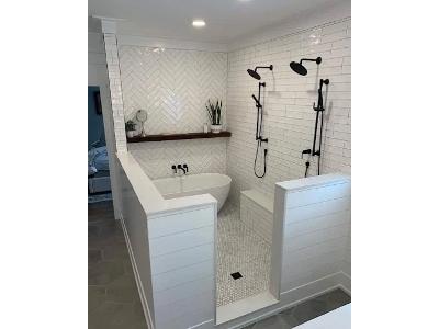 The image shows a recently renovated, luxurious bathroom featuring a modern, spa-like atmosphere. The company, A Plus Plumbing & Drain Cleaning, based in Alton, IL, offers comprehensive plumbing services for both residential and commercial clients.
