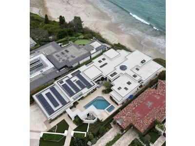 The image is an aerial view of a luxurious, modern beachfront residential property. This type of high-value property often requires the specialized, comprehensive restoration services offered by companies like Crown Reconstruction Services Inc.