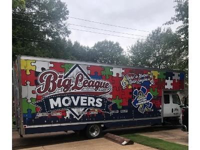 The image displays a large commercial moving truck with a striking, full-color vinyl wrap advertising Big League Movers.