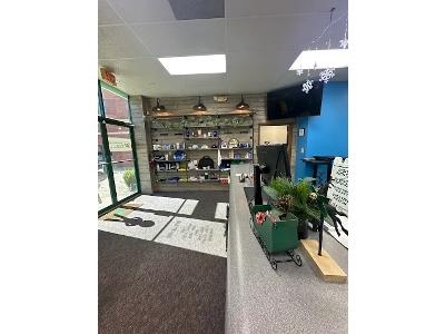 The dark gray athletic shirt with the "Quality Roofing Pro" logo being processed on a bright green machine is an excellent illustration of the custom apparel services offered by Minuteman Press.