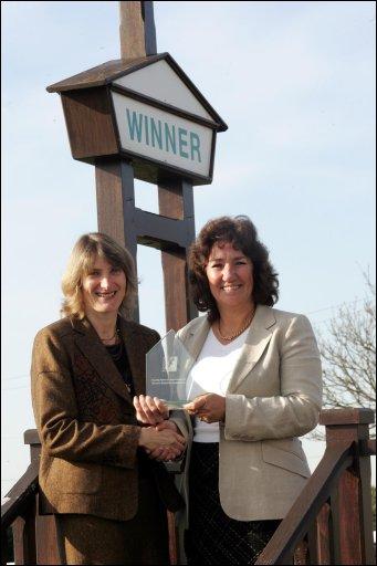 Sarah McPherson from Prowess (left) presenting the Flagship Award to Bev Hurley, head of YTKO (right).