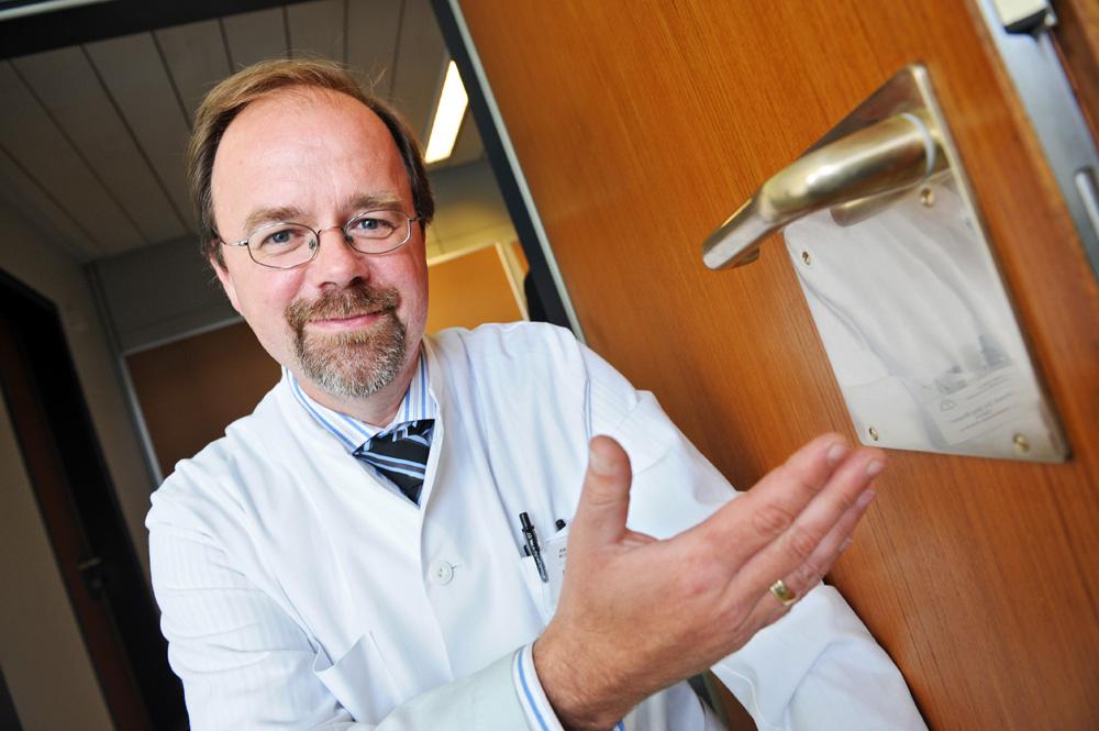 Professor Jörg Braun, MD, Chief Physician of the I. Medical Department at Asklepios Clinic Wandsbek, Hamburg, shows a door handle made of copper.